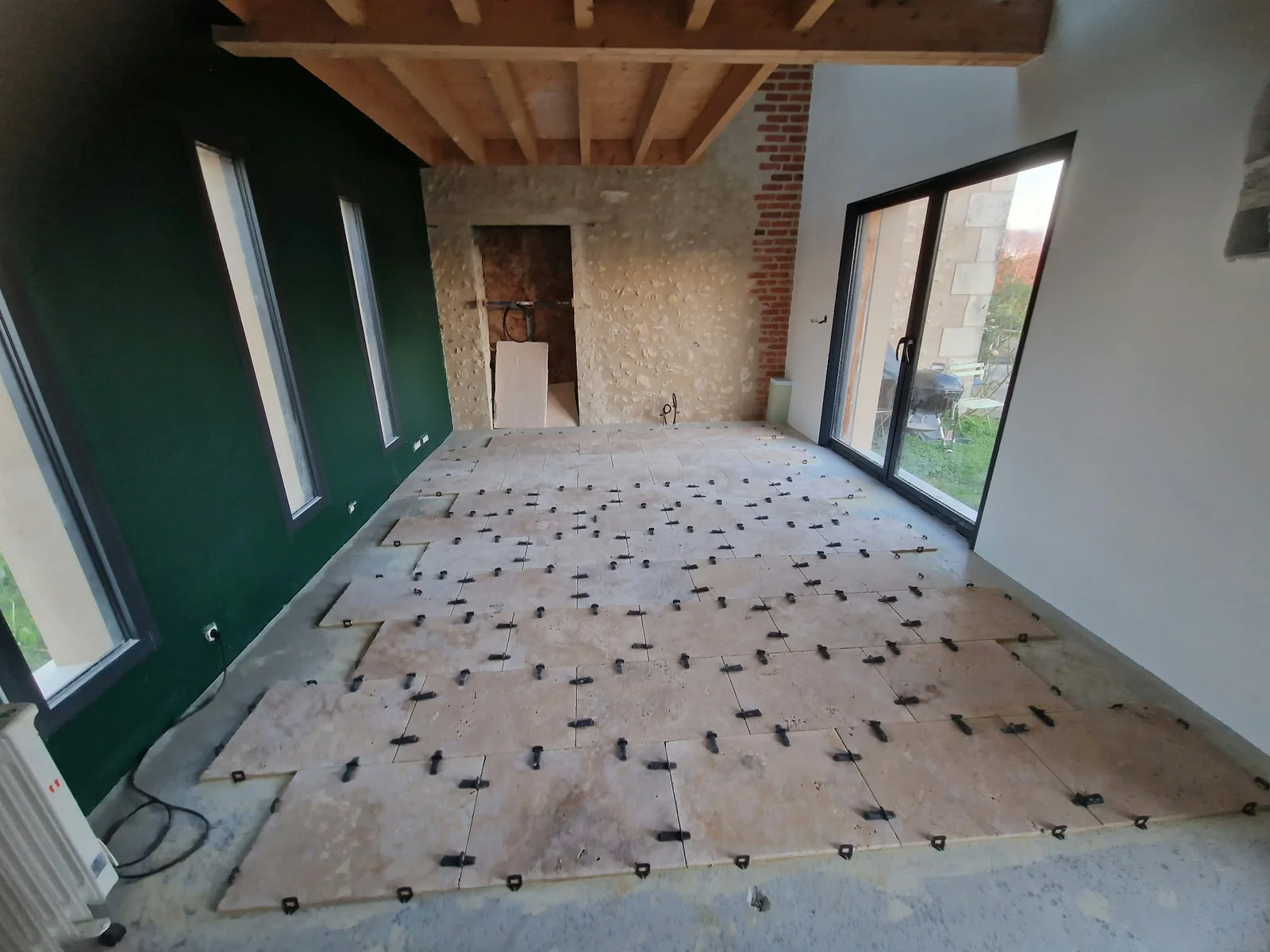 Pose du sol dans une pièce aux murs de pierre — Travaux en cours