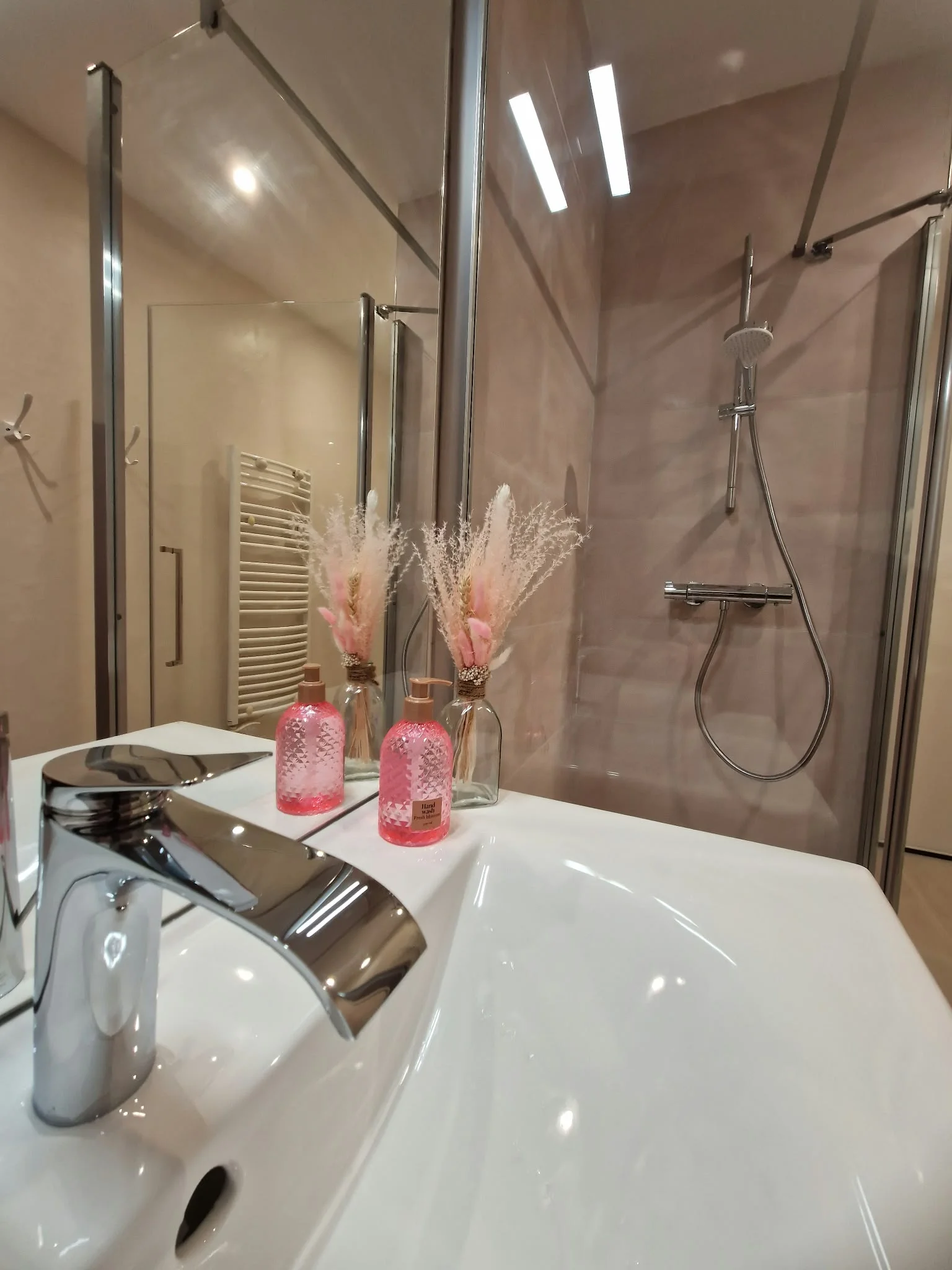 Salle de bain rénovée avec douche vitrée et vasque blanche