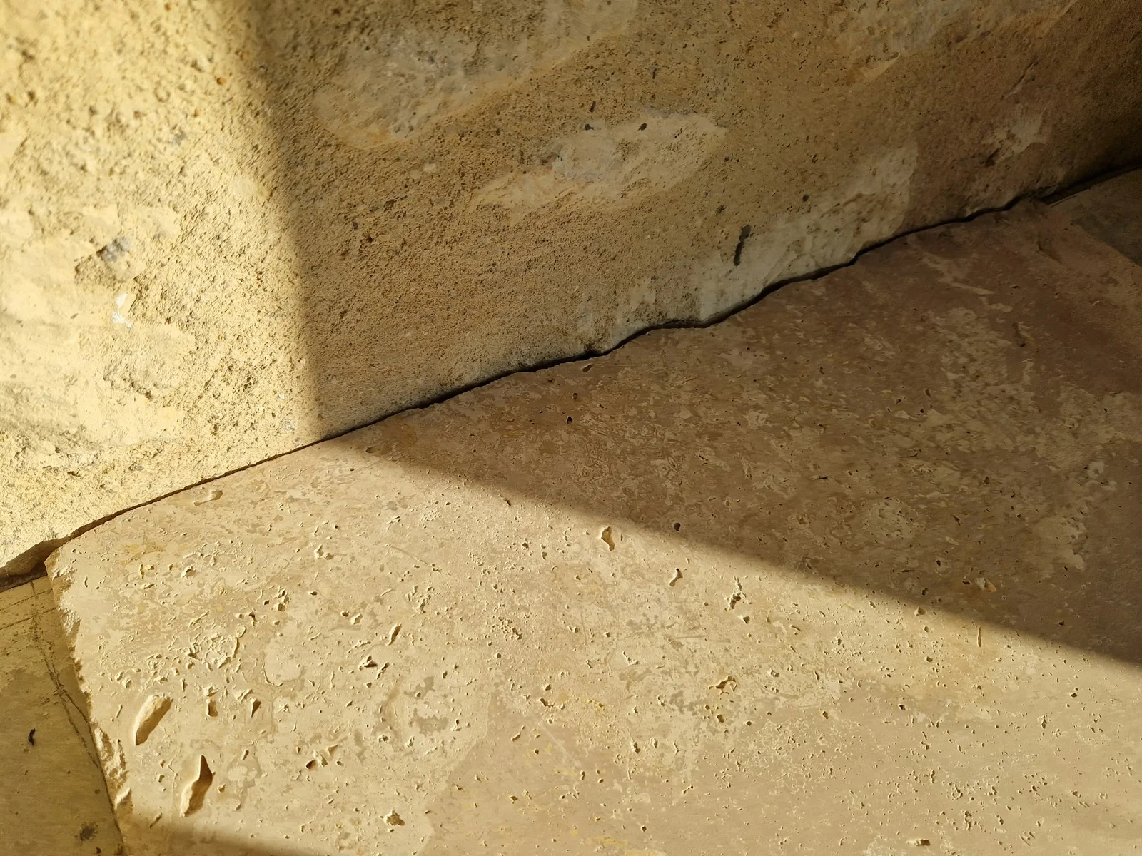 Découpe du revêtement au pied du mur en pierre — Détail de pose